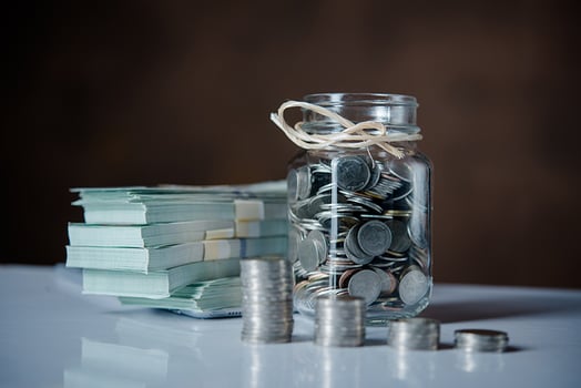 bottles-cash-with-coins-saving-money-concept Image by jcomp on Freepik